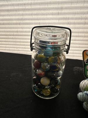 A JAR AND UNOPENED BAG OF MARBLES