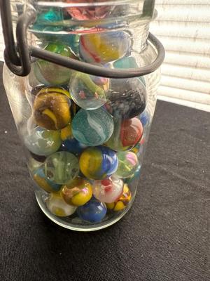 A JAR AND UNOPENED BAG OF MARBLES