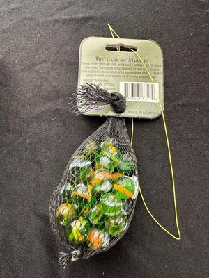 UNOPENED JUNGLE BAG AND A TIN OF MISC MARBLES