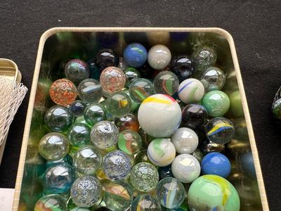 UNOPENED JUNGLE BAG AND A TIN OF MISC MARBLES