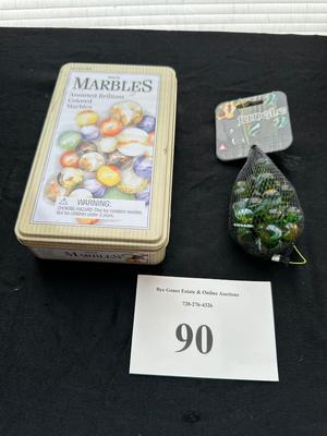 UNOPENED JUNGLE BAG AND A TIN OF MISC MARBLES