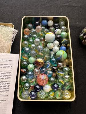 UNOPENED JUNGLE BAG AND A TIN OF MISC MARBLES