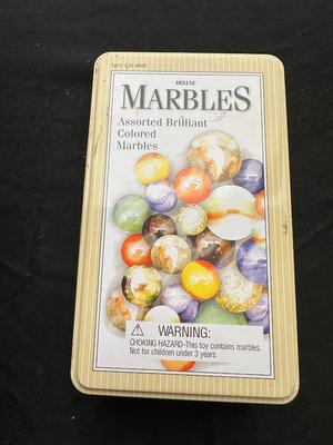 UNOPENED JUNGLE BAG AND A TIN OF MISC MARBLES