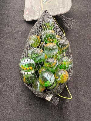 UNOPENED JUNGLE BAG AND A TIN OF MISC MARBLES