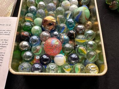 UNOPENED JUNGLE BAG AND A TIN OF MISC MARBLES