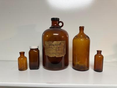 BROWN GLASS JUG AND BOTTLES