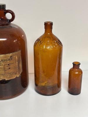 BROWN GLASS JUG AND BOTTLES