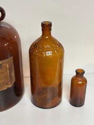 BROWN GLASS JUG AND BOTTLES