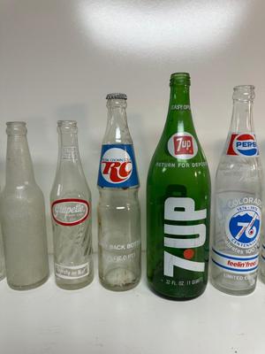 A VARIETY OF GLASS SODA POP BOTTLES