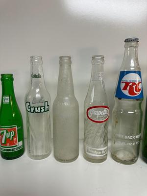 A VARIETY OF GLASS SODA POP BOTTLES