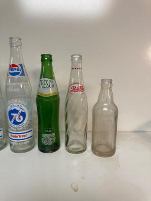 A VARIETY OF GLASS SODA POP BOTTLES
