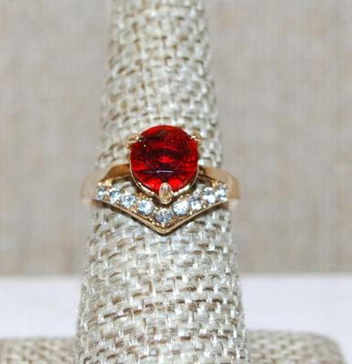 Size 6¾ Red 3 Prong Single Center Stone Ring with a "V" Accent of Clear Stones on a Gold Tone Band (2.8g)