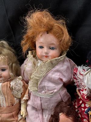 Sale Photo Thumbnail #101: German and French bru Spanish Dancer, plastic doll without her head. madam Alexander book. Porcelain babies, soft ethnic dolls. I found the other boot for the wood chopper. There are 2 music box dolls, and a Raggedy Andy. 2 bells
