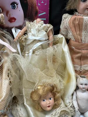 Sale Photo Thumbnail #99: German and French bru Spanish Dancer, plastic doll without her head. madam Alexander book. Porcelain babies, soft ethnic dolls. I found the other boot for the wood chopper. There are 2 music box dolls, and a Raggedy Andy. 2 bells