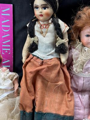 Sale Photo Thumbnail #110: German and French bru Spanish Dancer, plastic doll without her head. madam Alexander book. Porcelain babies, soft ethnic dolls. I found the other boot for the wood chopper. There are 2 music box dolls, and a Raggedy Andy. 2 bells