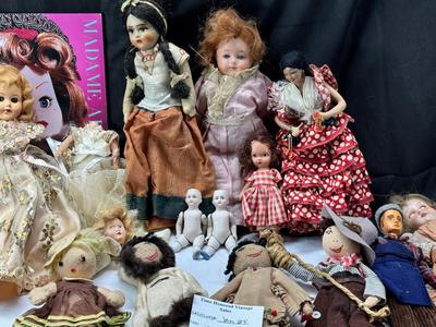 Sale Photo Thumbnail #116: German and French bru Spanish Dancer, plastic doll without her head. madam Alexander book. Porcelain babies, soft ethnic dolls. I found the other boot for the wood chopper. There are 2 music box dolls, and a Raggedy Andy. 2 bells