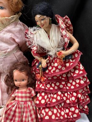 Sale Photo Thumbnail #102: German and French bru Spanish Dancer, plastic doll without her head. madam Alexander book. Porcelain babies, soft ethnic dolls. I found the other boot for the wood chopper. There are 2 music box dolls, and a Raggedy Andy. 2 bells