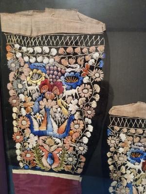 Sale Photo Thumbnail #302: Embroidery includes flowers, leaves, vines, people, animals, birds/peacocks Frame, 19 3/8" x 26", Sleeves approx. 6 1/2" x 13".