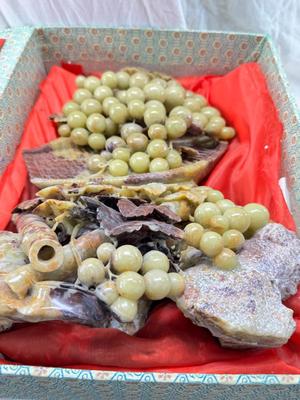 Sale Photo Thumbnail #277: Realistic grapes in a basket sits on  the raw rock base. Very large and heavy Rock sculpture, cannot be shipped. 16" tall with original padded box.