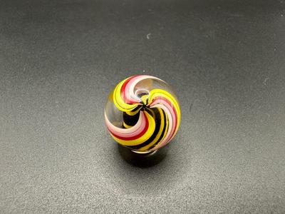 YELLOW AND BLACK STRIPED CORE MARBLE CAGED IN WHITE, PINK, RED AND YELLOW SWIRLS