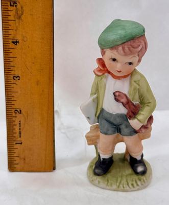 Sale Photo Thumbnail #226: Boy holding sheet music and a violin. Bisque ceramic made in Taiwan for Action.  Good condition, approx. 4.5" tall.