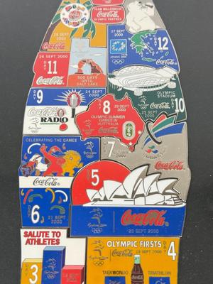 LOT 110: Framed Limited Edition Coca-Colay Sydney 2000 Olympics Bottle Puzzle Pin Set