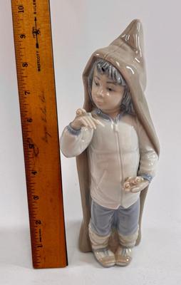 Sale Photo Thumbnail #608: Lladro "Boy with Snails" porcelain figurine, model number 4896. Approx. 9" tall.Release in 1974 and retired in 1979.