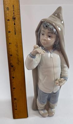 Sale Photo Thumbnail #607: Lladro "Boy with Snails" porcelain figurine, model number 4896. Approx. 9" tall.Release in 1974 and retired in 1979.