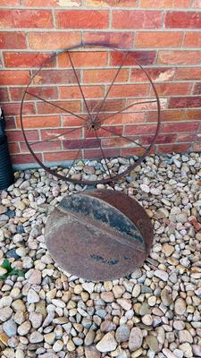IRON WHEEL AND A ROUND CAST IRON DISC WITH A LIP