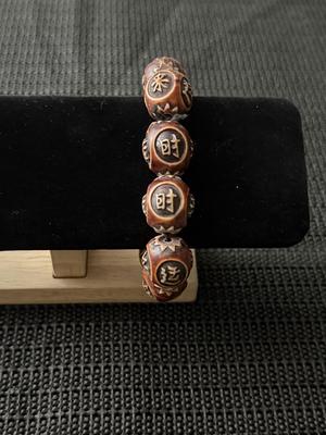 carved horn or wood bracelet featuring beads with Chinese characters
