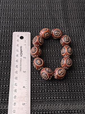 carved horn or wood bracelet featuring beads with Chinese characters