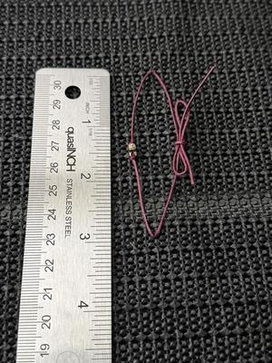 graduation wish bracelet with a star charm on a maroon cord.