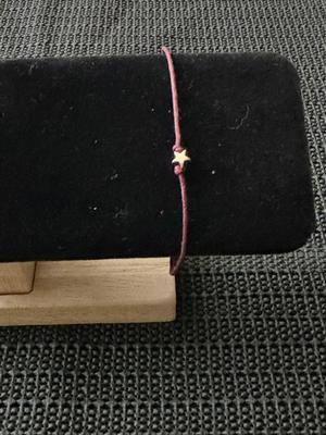 graduation wish bracelet with a star charm on a maroon cord.