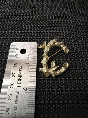 vintage Sarah Coventry gold-tone initial "C" brooch featuring a tree branch and leaf design.