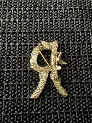 vintage Sarah Coventry initial "R" brooch pin, featuring a gold-tone metal design shaped like branches and leaves.