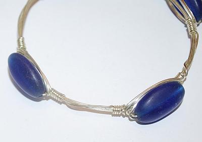 Silver Tone WIRED BRACELET (2¾" Opening) with 4 Long Oval Opaque BLUE Accents