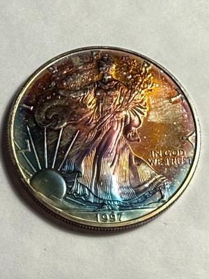 1997 CHOICE UNCIRCULATED CONDITION ALBUM TONED SILVER EAGLE DOLLAR AS PICTURED.