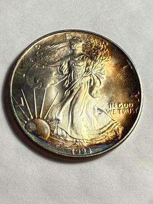 1994 CHOICE UNCIRCULATED CONDITION ALBUM TONED SILVER EAGLE DOLLAR AS PICTURED.