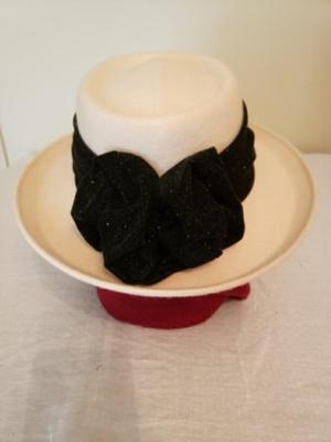 Women's cream colored fedora hat with a black ribbon and bow