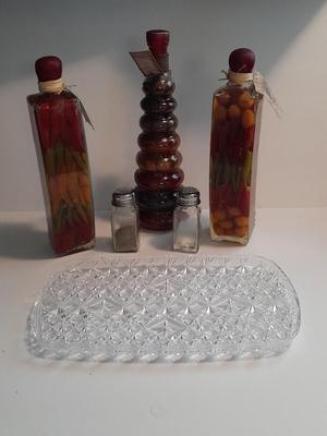 Decorative bottles of oil & vinegars a small platter and salt & pepper shakers