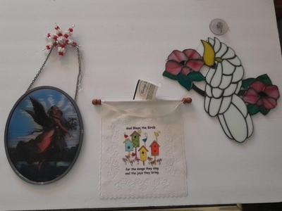 Stained glass window hangings and a small God bless the birds Tapestry.