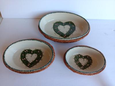 Three heart design nesting bowls each with its own basket.  Heavy ceramic