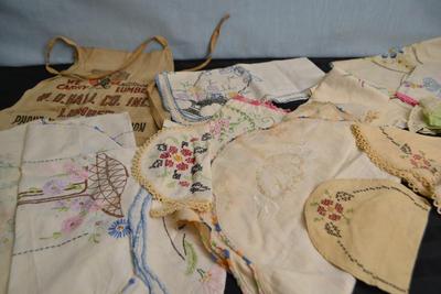 LOT 55. LUMBER YARD APRON AND EMBROIDERED VINTAGE LINENS
