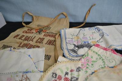 LOT 55. LUMBER YARD APRON AND EMBROIDERED VINTAGE LINENS