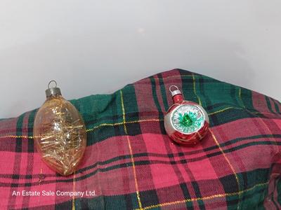 Two Christmas ornaments - one with tinsel inside and one that is indented.