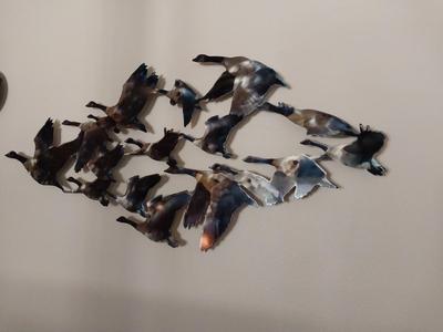 A GAGGLE OF 3D, STEEL GEESE FLYING NORTH
