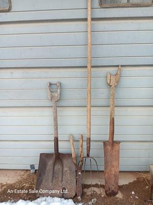 Two antique shovels with wood handles an old pitchfork and some trimmers