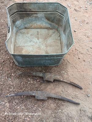 Metal wash tub with two vintage pickaxe heads