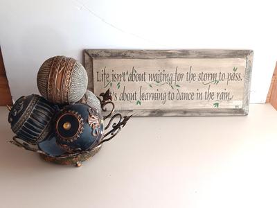 Metal Fleur De Lis accented dish with 4 large decorative balls and a sawdust city wood sign with saying.