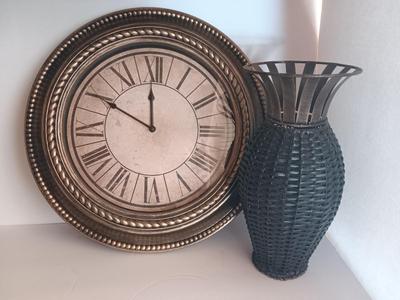 Roman numeral wall clock with woven metal vase decor